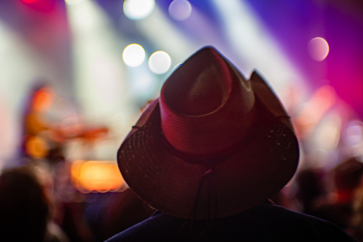 Guest wearing a cowboy hat enjoying live country music in Nashville